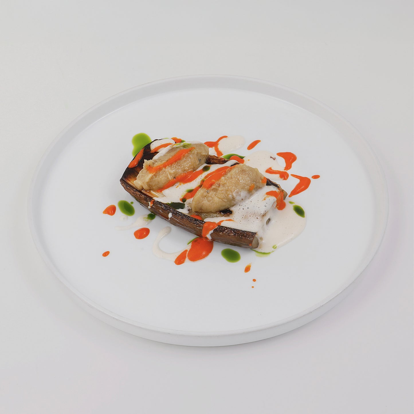 Roasted aubergin, tomato sauce, white sauce, basil oil