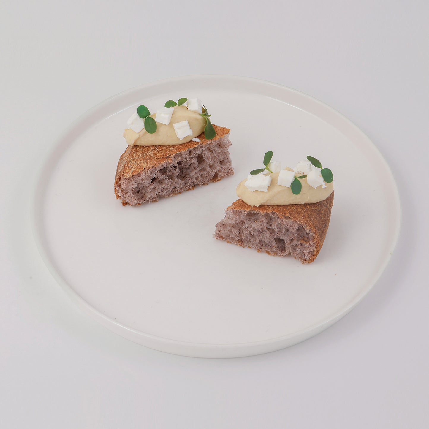 Venere black rice flour pizza, chickpea hummus and feta cheese